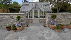 Traditional glasshouse forming the centrepiece of a landscaped country garden in Somerset