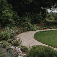 Gravel path sweeping between mixed planting and the circular lawn, Over Stowey