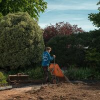 Sibley Landscapes team member barrowing material across the excavated garden during the build