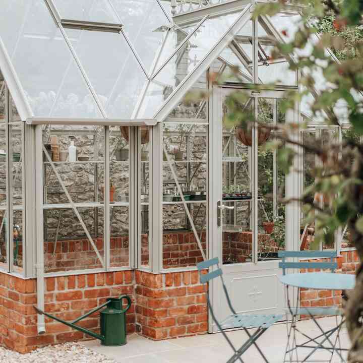 Glazed greenhouse roof and ridge finials seen from the walled garden