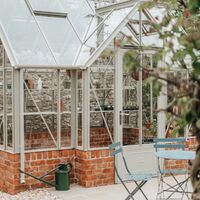 Glazed greenhouse roof and ridge finials seen from the walled garden