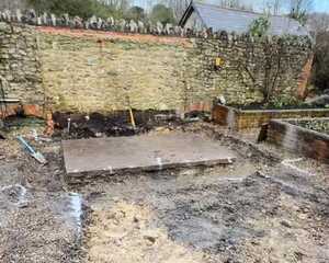 Cleared ground and old concrete base in the walled garden before the greenhouse build