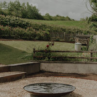 Water feature and gravel terrace on a sloping garden, Weare, Axbridge