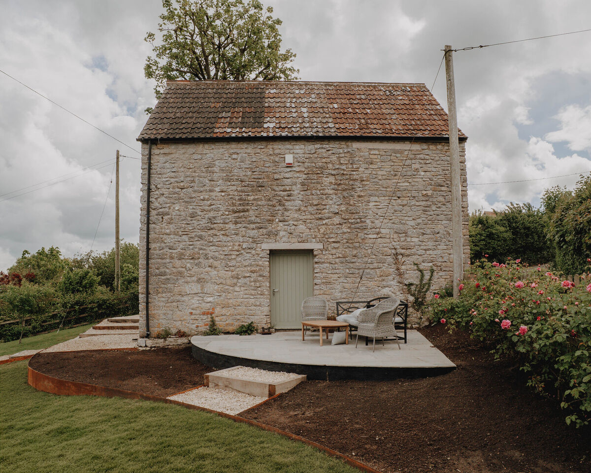 Stone outbuilding with new lawn and terracing, sloping garden, Axbridge