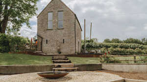 Terraced sloping garden with steps and gravel after landscaping, stone outbuilding behind, Weare, near Axbridge