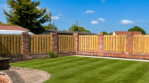Open family garden with a neatly maintained striped lawn enclosed by tall timber fence panels